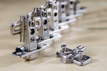 Carpentry tools and accessories on a workshop table. Hinges and screws together with the screwdriver in the workshop.